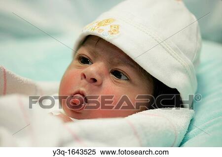Stock Photography - Two day old baby sticks her tongue out in a confident, playful gesture.. Fotosearch