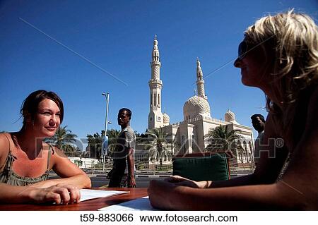Two european women sitting at caf? in front of Jumeira Mosque. Dubai City. Dubai. United Arab Emirates View Large Photo Image Stock Photograph - Two european women sitting at caf? in front of Jumeira Mosque. Dubai City. Dubai. United Arab Emirates. Fotosearch