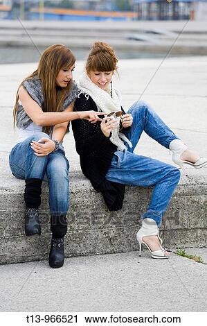 Two fanciful girls are commenting eyeglasses View Large Photo Image Stock Image - Two fanciful girls are commenting eyeglasses. Fotosearch