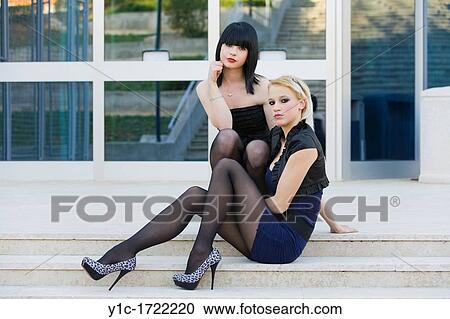 Stock Image - Two fanciful young women are posing on stairs. Fotosearch
