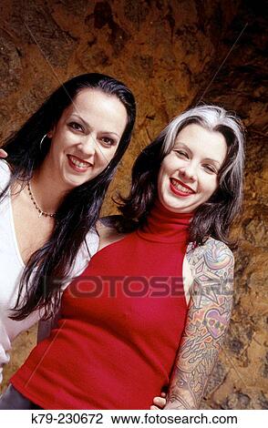Two female friends smiling at camera View Large Photo Image Stock Image - Two female friends smiling at camera. Fotosearch