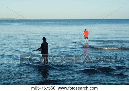 Stock Image - Two fishermen casting in Fannie Bay, Northern Territory, Australia. Fotosearch