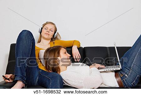 Two friends enjoying leisure at home View Large Photo Image Stock Image - Two friends enjoying leisure at home. Fotosearch