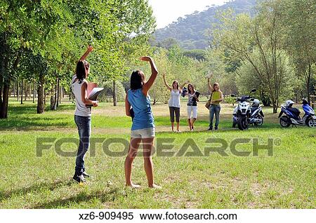 Stock Photography - Two friends greet each other three that have come on a motorcycle. Fotosearch