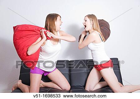 Two friends having a pillow fight View Large Photo Image Stock Image - Two friends having a pillow fight. Fotosearch