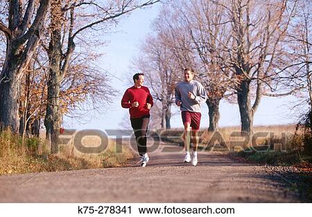 Stock Image - two friends running on a country road. Fotosearch