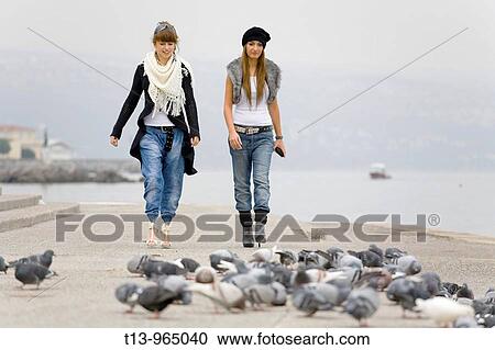 Two girlfriends and a flock of pigeons View Large Photo Image Stock Image - Two girlfriends and a flock of pigeons. Fotosearch