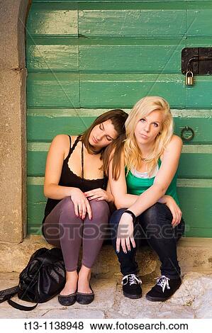 Two girlfriends are sitting tired on the porch after a night out View Large Photo Image Stock Photo - Two girlfriends are sitting tired on the porch after a night out. Fotosearch