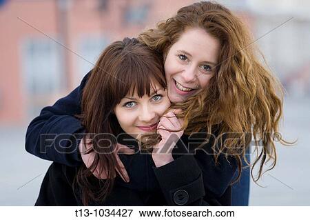 Stock Photo - Two girlfriends are smiling. Fotosearch