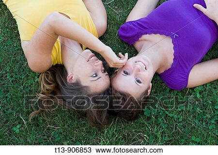 Two girlfriends happy on meadow View Large Photo Image Stock Image - Two girlfriends happy on meadow. Fotosearch