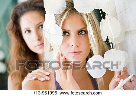 Stock Photograph - Two girlfriends playing with room decoration. Fotosearch