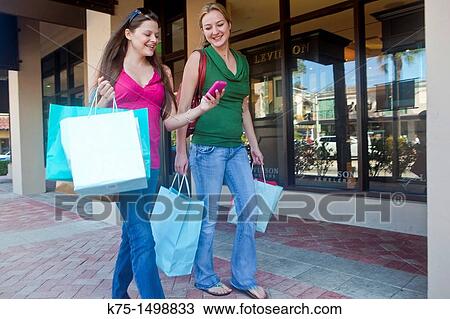 Two girlfriends shopping and talking View Large Photo Image Stock Image - Two girlfriends shopping and talking. Fotosearch