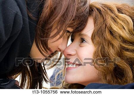 Two girlfriends smile to each other View Large Photo Image Stock Photograph - Two girlfriends smile to each other. Fotosearch