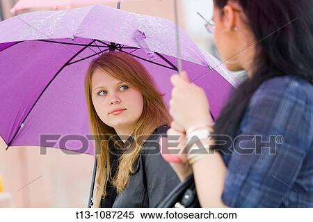Two girlfriends under umbrellas View Large Photo Image Stock Photography - Two girlfriends under umbrellas. Fotosearch