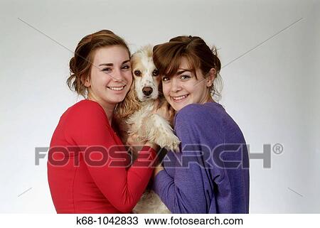 Two girls, 14 and 18, in studio with dog View Large Photo Image Stock Image - Two girls, 14 and 18, in studio with dog. Fotosearch