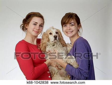 Two girls, 14 and 18, in studio with dog View Large Photo Image Stock Photo - Two girls, 14 and 18, in studio with dog. Fotosearch