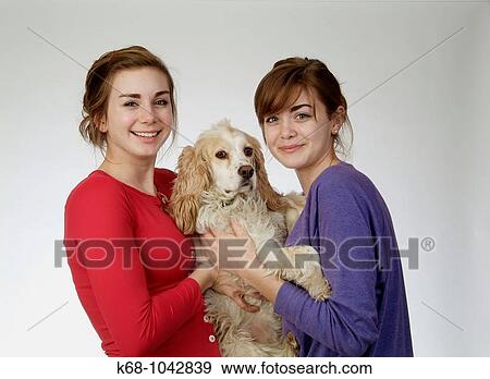 Two girls, 14 and 18, in studio with dog View Large Photo Image Stock Photo - Two girls, 14 and 18, in studio with dog. Fotosearch