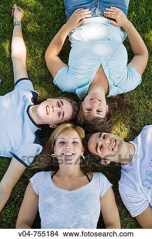 Two girls and two boys lying in the grass View Large Photo Image Picture - Two girls and two boys lying in the grass. Fotosearch
