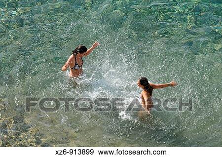 Stock Photo - two girls bathing in the sea. Fotosearch