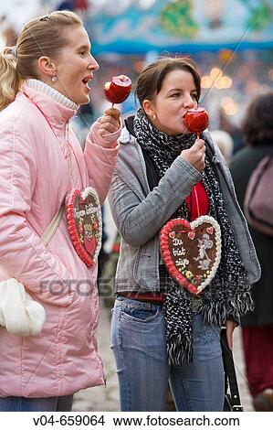 Two girls eating glaced apples at the Bremen Annual Fair in Germany, Europe View Large Photo Image Picture - Two girls eating glaced apples at the Bremen Annual Fair in Germany, Europe. Fotosearch