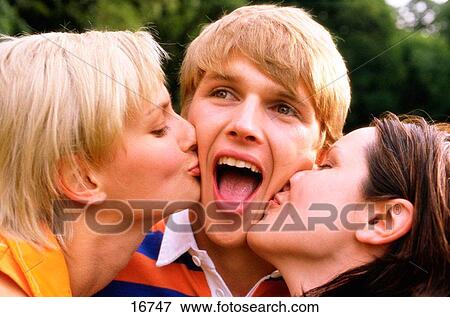 Two girls kissing boy View Large Photo Image Stock Photo - Two girls kissing boy. Fotosearch