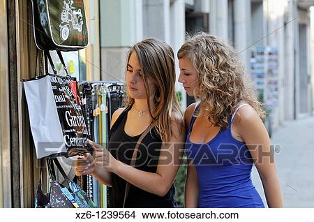 Two girls looking at a bag in a tourist shop, Girona, Catalonia, Spain, Europe View Large Photo Image Picture - Two girls looking at a bag in a tourist shop, Girona, Catalonia, Spain, Europe. Fotosearch