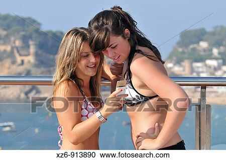 two girls looking at pictures on a mobile View Large Photo Image Stock Image - two girls looking at pictures on a mobile. Fotosearch