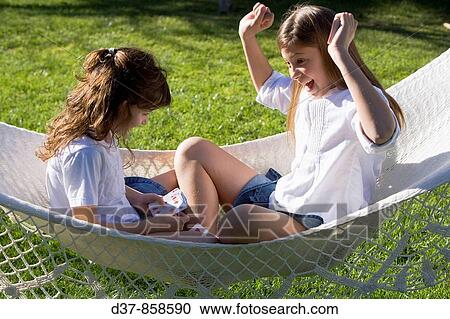Two girls playing cards in the garden View Large Photo Image Stock Image - Two girls playing cards in the garden. Fotosearch