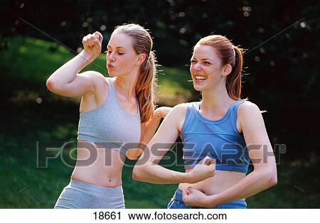 Stock Image - Two girls showing muscles. Fotosearch