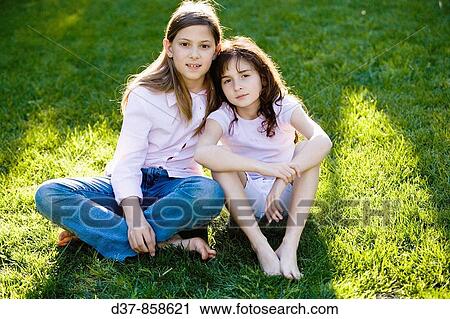 Two girls siting in the garden looking at the camera View Large Photo Image Stock Image - Two girls siting in the garden looking at the camera. Fotosearch