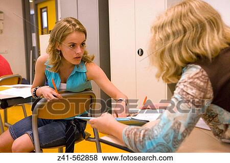 Stock Photo - Two girls talking in the classroom. Fotosearch