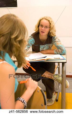 Stock Photograph - Two girls talking in the classroom. Fotosearch