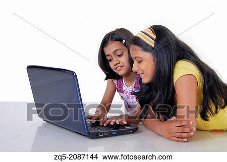 Picture - Two girls using a laptop computer, Pune, India.. Fotosearch