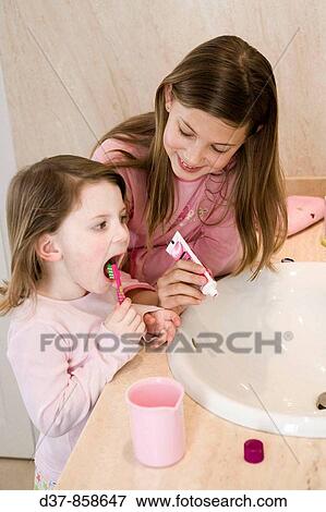 Two girls washing their teeth View Large Photo Image Stock Photo - Two girls washing their teeth. Fotosearch