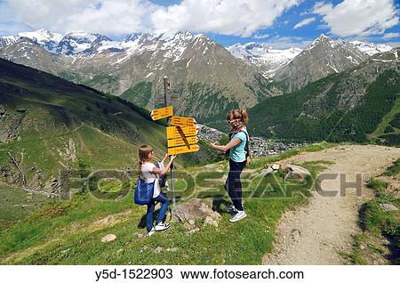 two girls watching directions for hiking in Swiss Alps, Valais, Switzerland View Large Photo Image Stock Image - two girls watching directions for hiking in Swiss Alps, Valais, Switzerland. Fotosearch