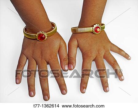Two gold bracelets in girl's hand, Maharashtra, India View Large Photo Image Picture - Two gold bracelets in girl's hand, Maharashtra, India. Fotosearch