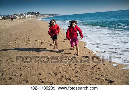 two happy children playing and running on the beach, Arenys de Mar, Barcelona, Spain View Large Photo Image Stock Photography - two happy children playing and running on the beach, Arenys de Mar, Barcelona, Spain. Fotosearch