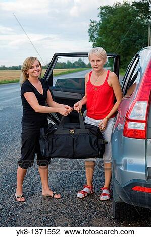 Two Happy Smiling Young Women Holding Nylon Sport Travel Bag by Car View Large Photo Image Stock Image - Two Happy Smiling Young Women Holding Nylon Sport Travel Bag by Car. Fotosearch