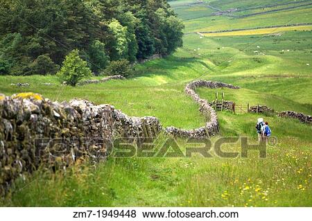Two hikers walking the route alongside Hadrians Wall. While the wall has long since gone, you can see the Vallum (v shape ditch) to the right. View Large Photo Image Stock Photo - Two hikers walking the route alongside Hadrians Wall. While the wall has long since gone, you can see the Vallum (v shape ditch) to the right.. Fotosearch