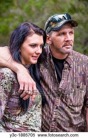 Stock Photography - Two hunters portrait, father and daughter in camouflage outfit, male Caucausian, 40 years old, female Caucasian with long black hair, 18 years old, Texas, USA. Fotosearch