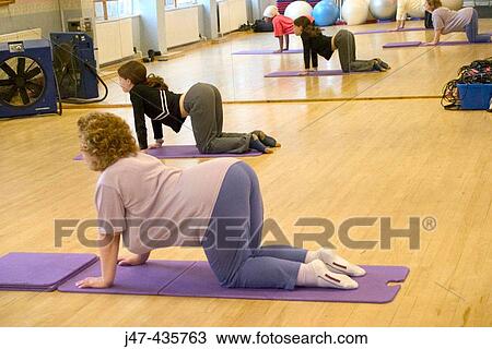 Two ladies doing the cat stretch on the floor in an exercise class at the gym View Large Photo Image Stock Image - Two ladies doing the cat stretch on the floor in an exercise class at the gym. Fotosearch