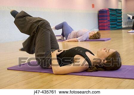Two ladies lying on the floor practicing pilates View Large Photo Image Stock Image - Two ladies lying on the floor practicing pilates. Fotosearch