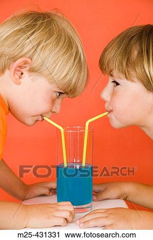 Two little boys drinking blue lemonade through straws out of the same glass sharing View Large Photo Image Stock Image - Two little boys drinking blue lemonade through straws out of the same glass sharing. Fotosearch