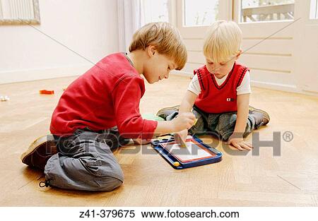 Two little boys playing together View Large Photo Image Stock Photography - Two little boys playing together. Fotosearch