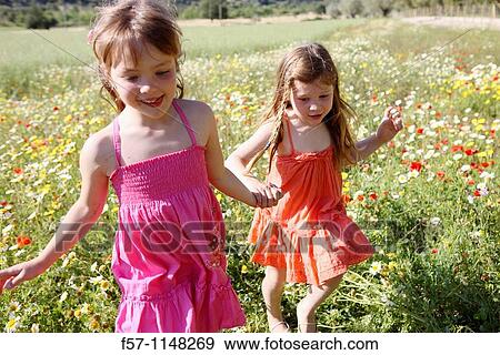 Two little girls in meadow View Large Photo Image Stock Photo - Two little girls in meadow. Fotosearch