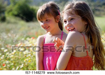 Two little girls in meadow View Large Photo Image Stock Photo - Two little girls in meadow. Fotosearch