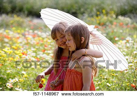 Two little girls in meadow View Large Photo Image Stock Photo - Two little girls in meadow. Fotosearch