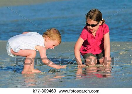 Two little girls (six and two years old) playing at the beach in Florida, USA. View Large Photo Image Stock Photo - Two little girls (six and two years old) playing at the beach in Florida, USA.. Fotosearch