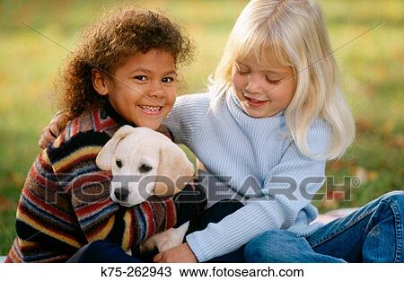 Stock Image - Two little girls with a puppy. Fotosearch