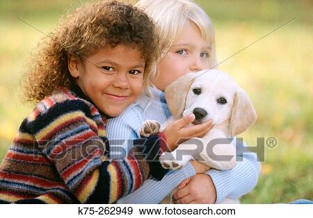Stock Photo - Two little girls with a puppy. Fotosearch
